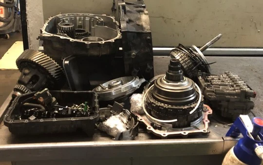 Rozložená převodovka automobilu s viditelnými díly a součástmi.