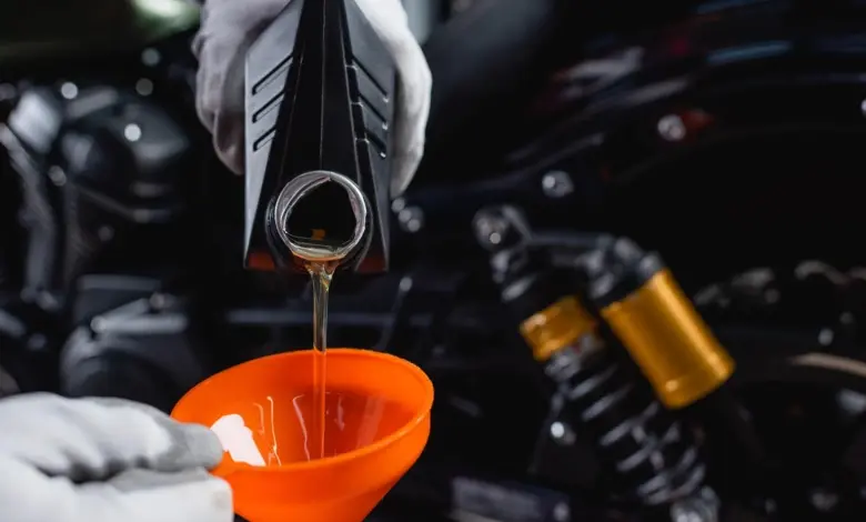 Lévání motorového oleje do funelu pro údržbu nebo smíchání olejů.