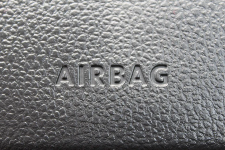 Zblízka viditelný nápis AIRBAG na texturovaném povrchu krytu.