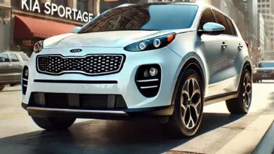Bílý automobil Kia Sportage jezdí po městské ulici.