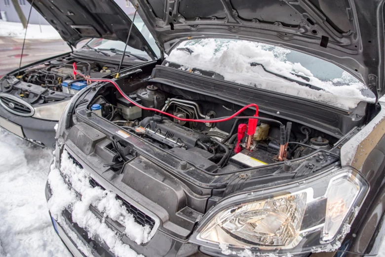 Autobaterie se připojuje k jinému autu pro startování v zimě.