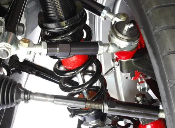 Detailní pohled na tlumič a pružinu v podvozku automobilu.