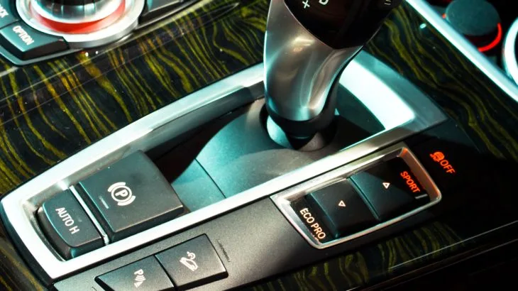 Automatická převodovka s tlačítkem parkovací brzdy v interiéru vozu.
