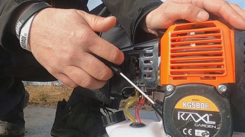 Ruční úprava jehly karburátoru pro nastavení optimálního výkonu motora.