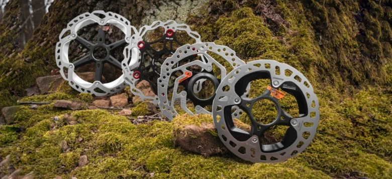 Čtyři brzdové kotouče pro bicykle na mchovém skále.