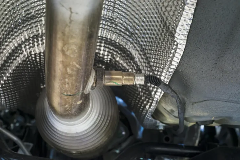 Lambda sonda připojená k výfukovému systému automobilu.