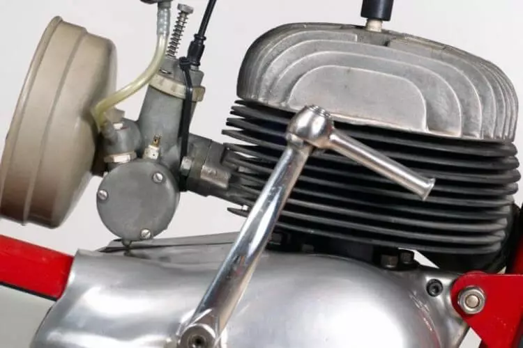 Blízký záběr na dvoudobý motor s chladičemi a karburátorem.