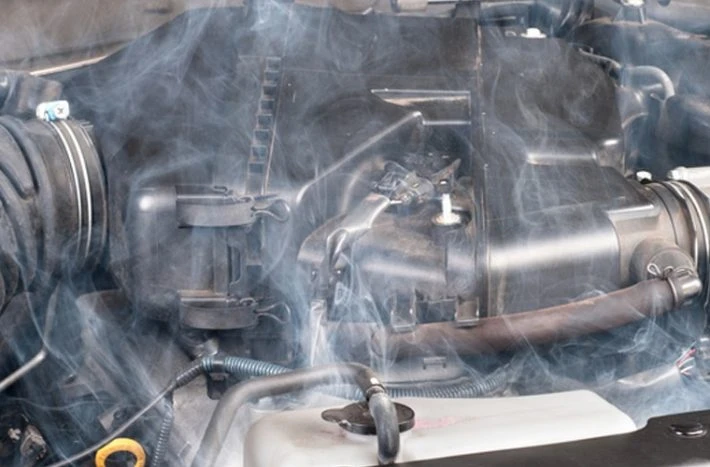 Dým vycházející z přehřátého motoru automobilu.