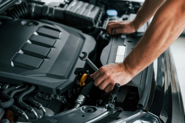 Mechanik opravuje motor vozu při poruše teplotního čidla.