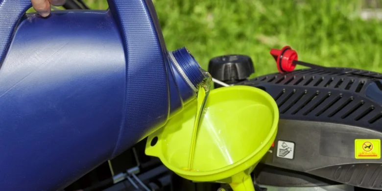 Nalévání oleje do motoru pomocí zeleného funelu.