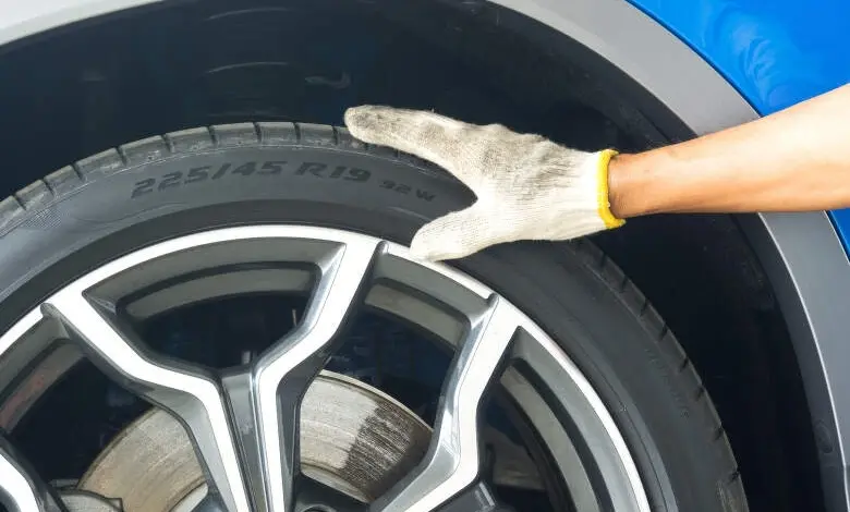Car tire and hand wearing glove