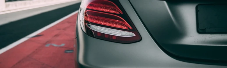 Detail zadního světlometu automobilu na silnici.