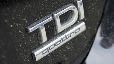 Bližší záběr na stříbrné logo TDi Quattro na černém karoserii.