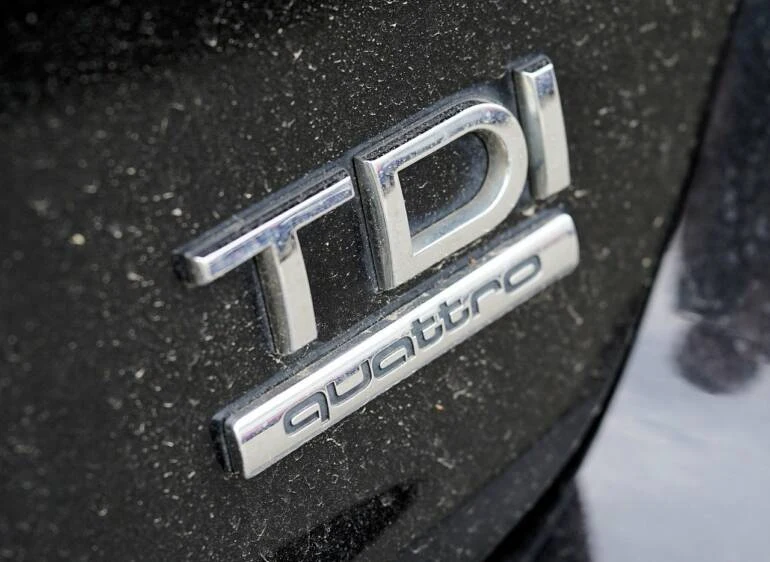 Bližší záběr na stříbrné logo TDi Quattro na černém karoserii.