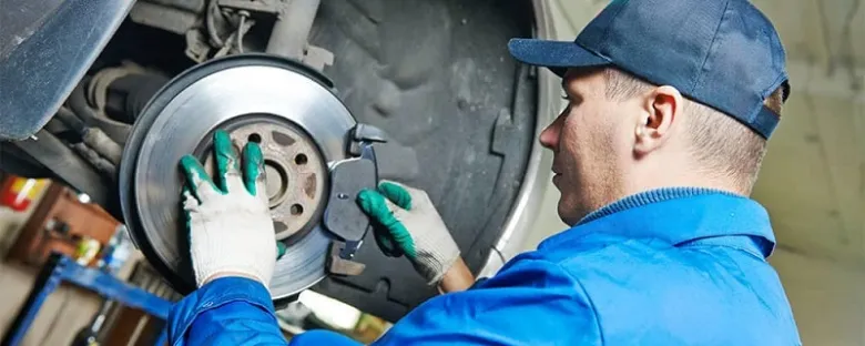 Mechanik opravuje brzdný disk u auta.