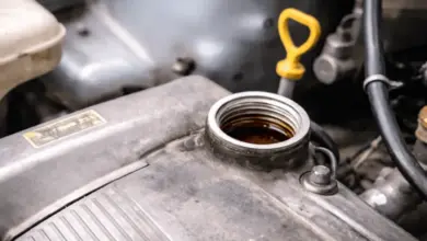 Otevřený nálevník s motorovým olejem vedle žlutého ukazatele hladiny.