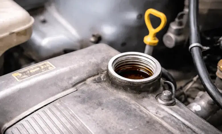 Otevřený nálevník s motorovým olejem vedle žlutého ukazatele hladiny.