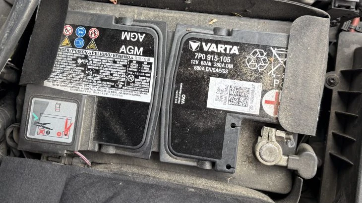 Černá automobilová baterie značky Varta s viditelnými pólů.