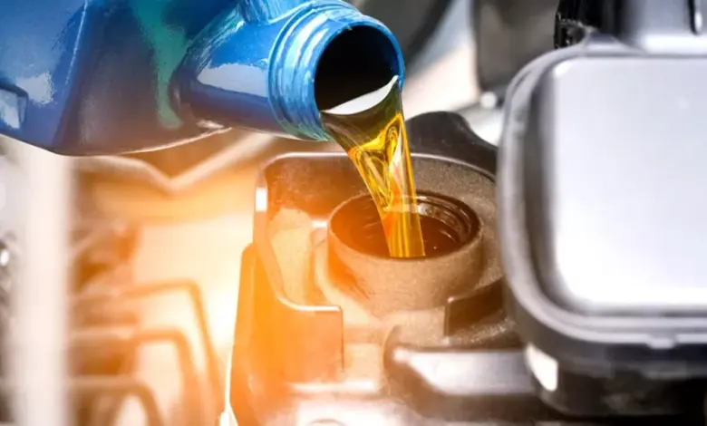 Zlatý olej se nalévá do otvoru pro výměnu oleje v automobilovém motoru.