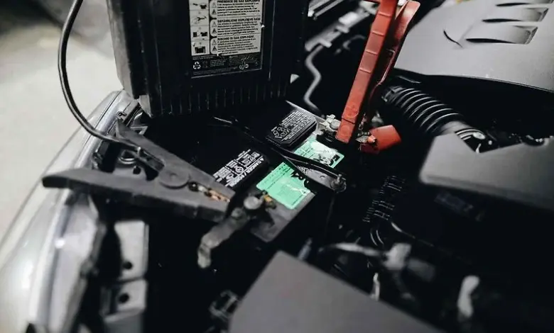 Připojení kabelů k novému autobaterii v motorovém prostoru