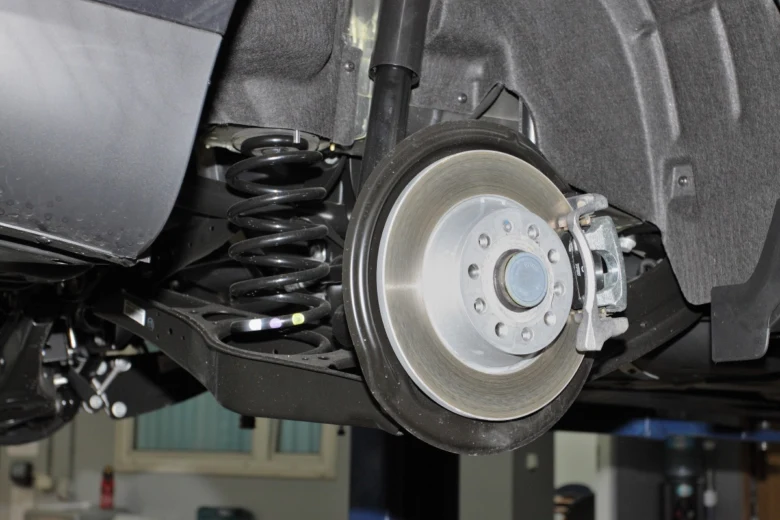 Detailní pohled na pružinu a brznu pod autem.