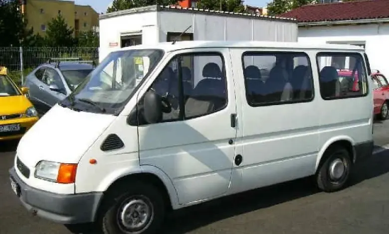 Bílý dodávkový vůz zaparkovaný na asfaltové ploše.