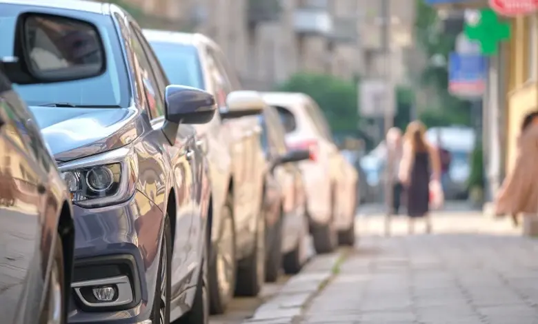 Řada zaparkovaných aut na ulici včetně stříbrného BMW.