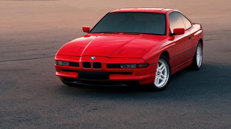 Červený sportovní vůz značky BMW na asfaltu.