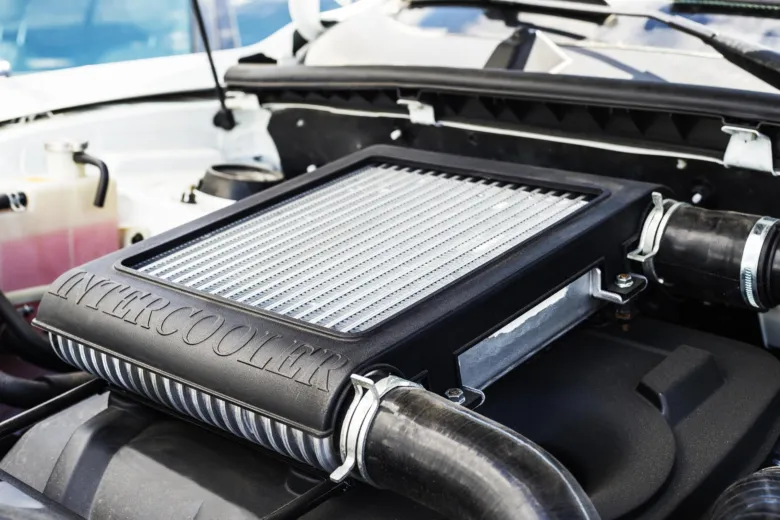 Interkooler v motorovém prostoru automobilu.