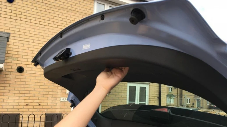 Ruka upravuje mechanismus pro automatické otevírání kufru u auta.