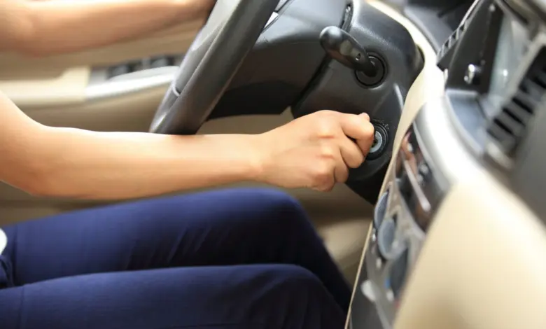 Osoba zapíná auto klíčem u volantu.