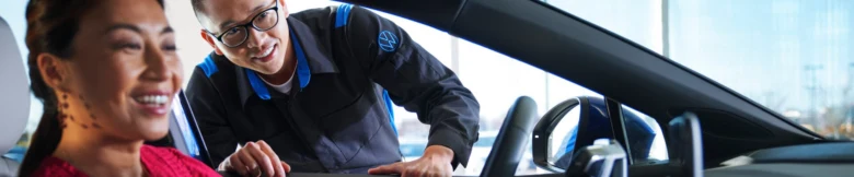 Prodejce Volkswagen vysvětluje zákaznici servisní reset v autě.