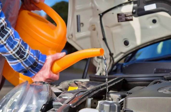 Lidá se voda do motoru pomocí oranžového funelu.