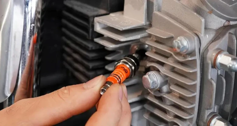 Ruční instalace nové svíčky do motoru motobloku.