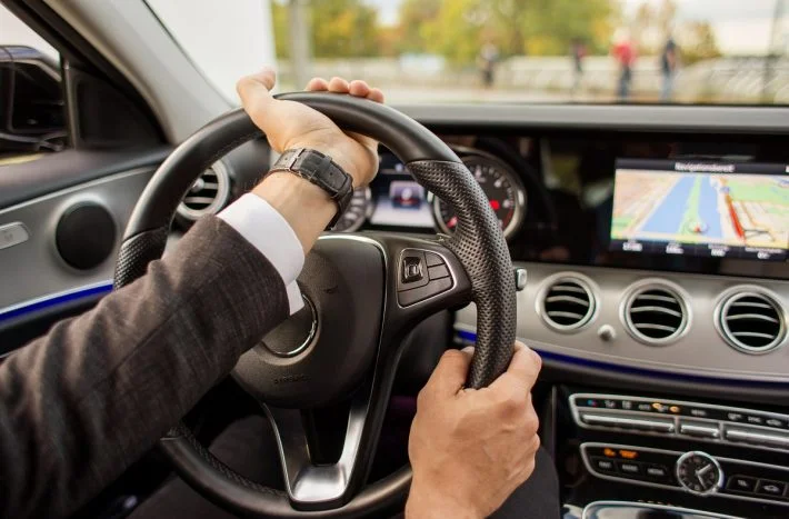 Ruce na volantu při řízení automobilu.