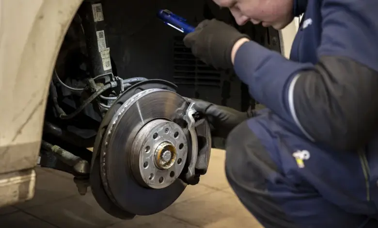 Mechanik kontroluje brzdový válec pomocí světla v dílně.