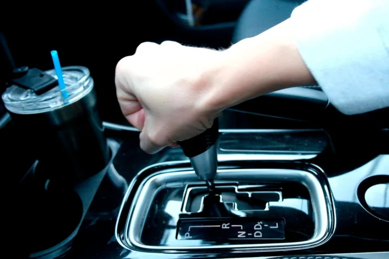 Ruka přepíná převodovku v automobilu s automatickou převodovkou.