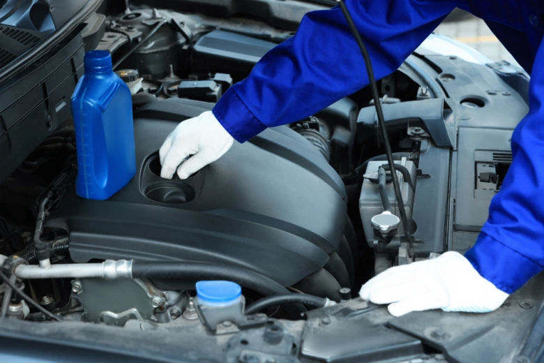 Mechanik nalévá olej do motoru při proplachu.
