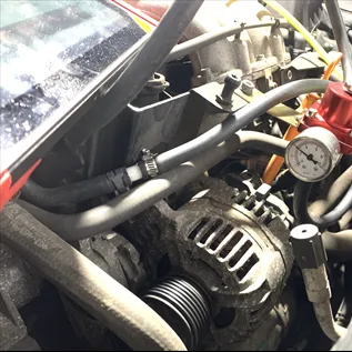 Motorový prostor auta s tlakoměrem a hadicemi pro diagnostiku chyby P0172