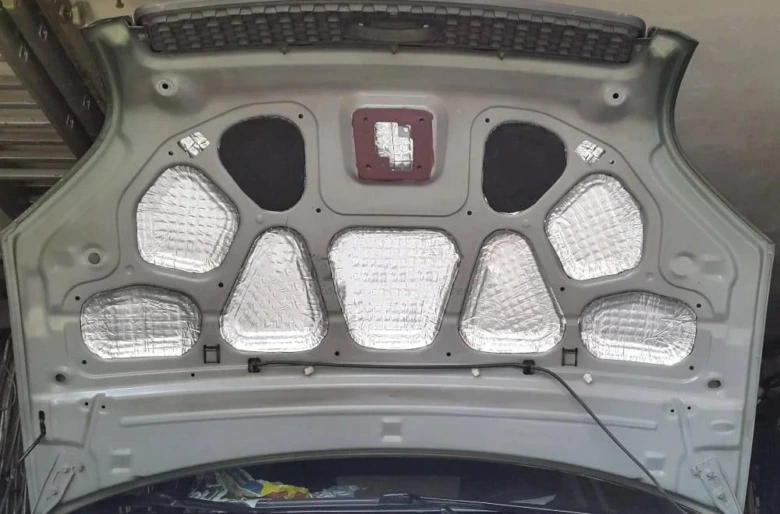 Izolační materiály pod kapotou automobilu pro zvukovou izolaci.