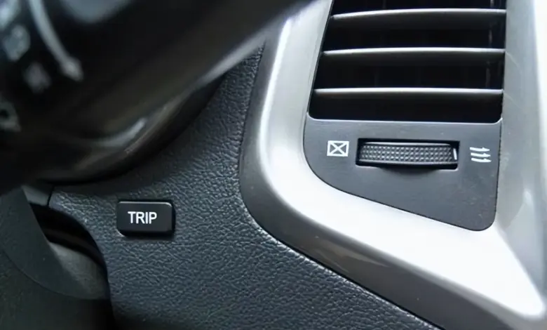 Tlačítko Trip pro resetování dojízdě v interiéru automobilu.