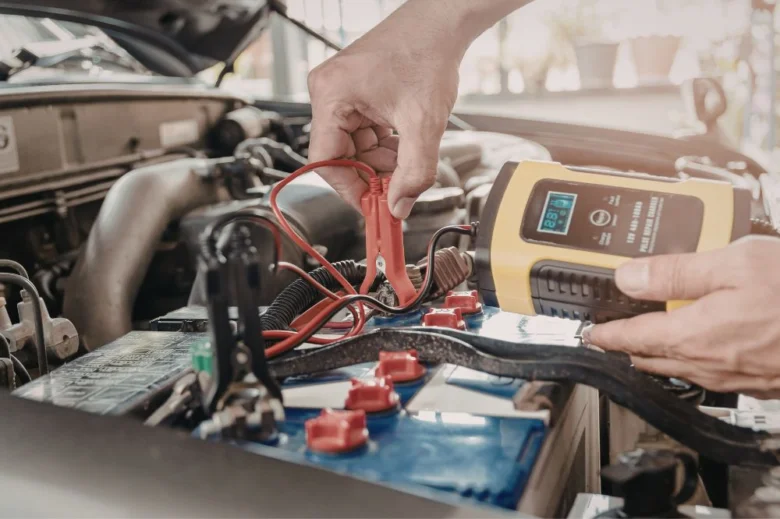 Testování autobaterie multimetrem v motorovém prostoru.