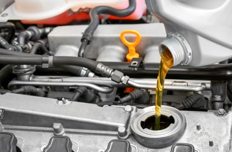 Zlatý olej se nalévá do motora při údržbě automobilu.