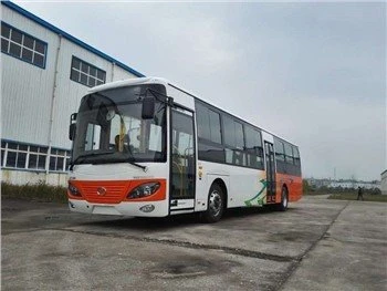 Bílý autobus s oranžovým předním dílem na betonové ploše.