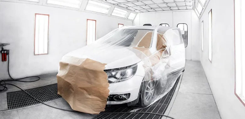 Bílé auto v lakovárně připraveno na profesionální barvení.