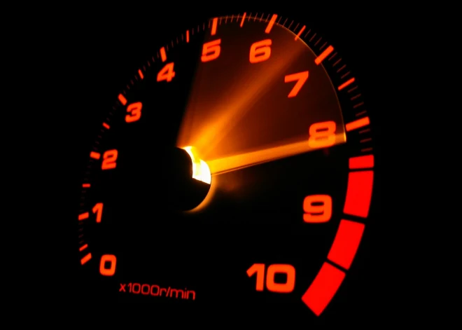 Červený tachometr ukazující otáčky motoru v obrazech za minutu.