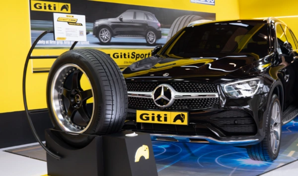 Černý automobil s nasazenou pneumatikou značky Giti na výstavním stánku.
