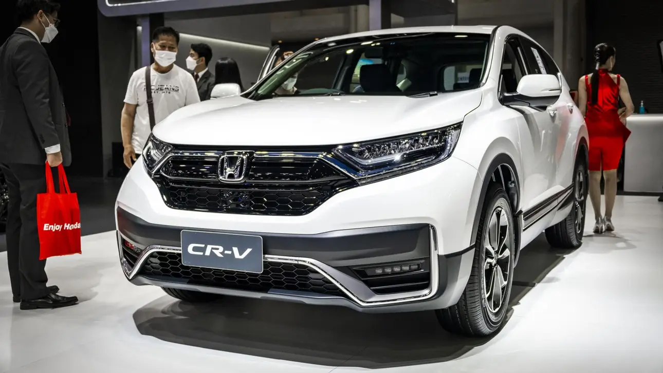 Bílý SUV Honda CR-V na autosalonu s lidmi kolem.