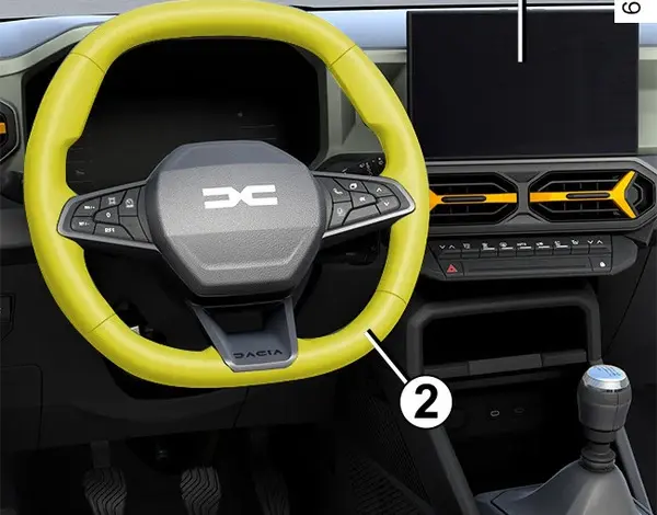 Interiér vozu s volantem značky Dacia a přístrojovou deskou.