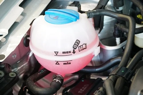 Prozředěná nádrž chladicí kapaliny v motoru automobilu.
